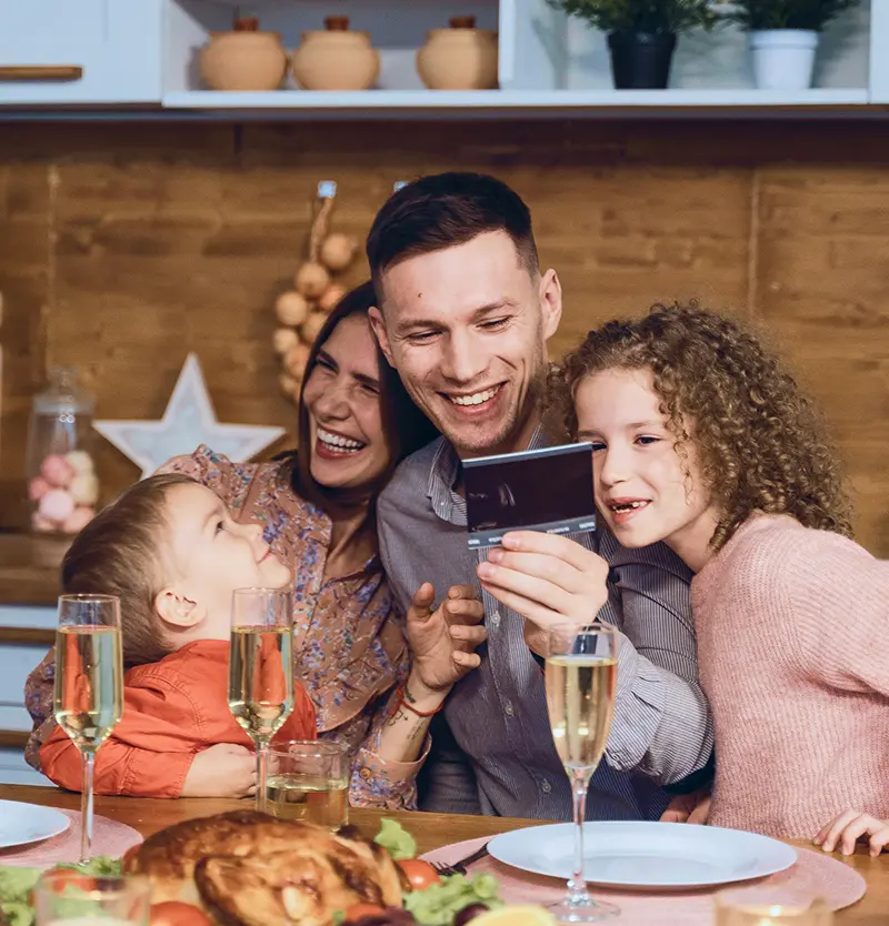 mother and father with kids around them happily looking at an ultrasound photo