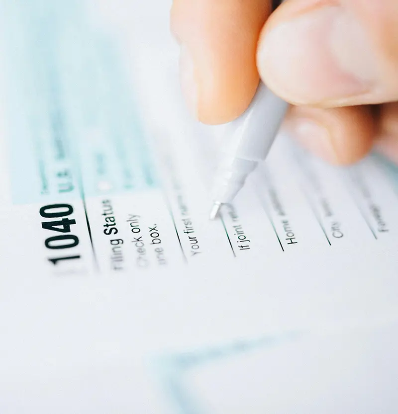person filling out their 1040 taxes