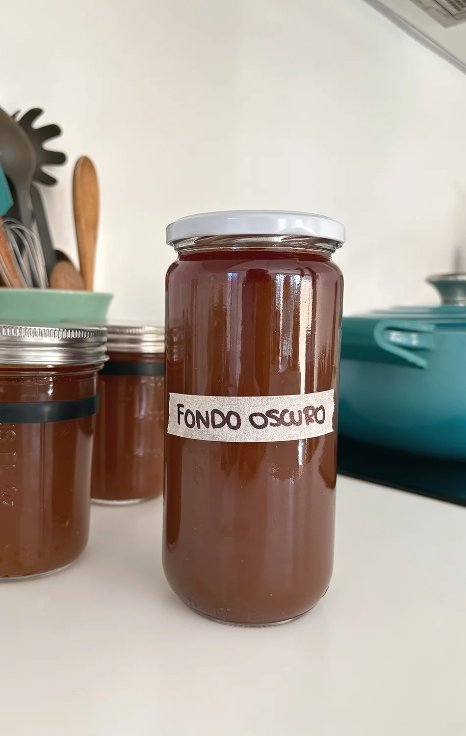 Three golden fried dough balls garnished with chopped herbs on a bed of red tomato sauce, served on a speckled white plate.