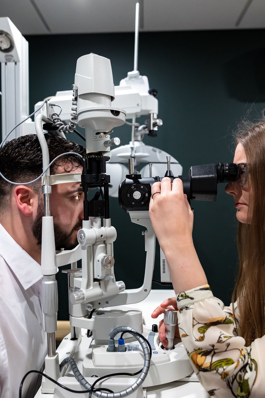 Eye doctor performing comprehensive eye exam using professional optical examination equipment
