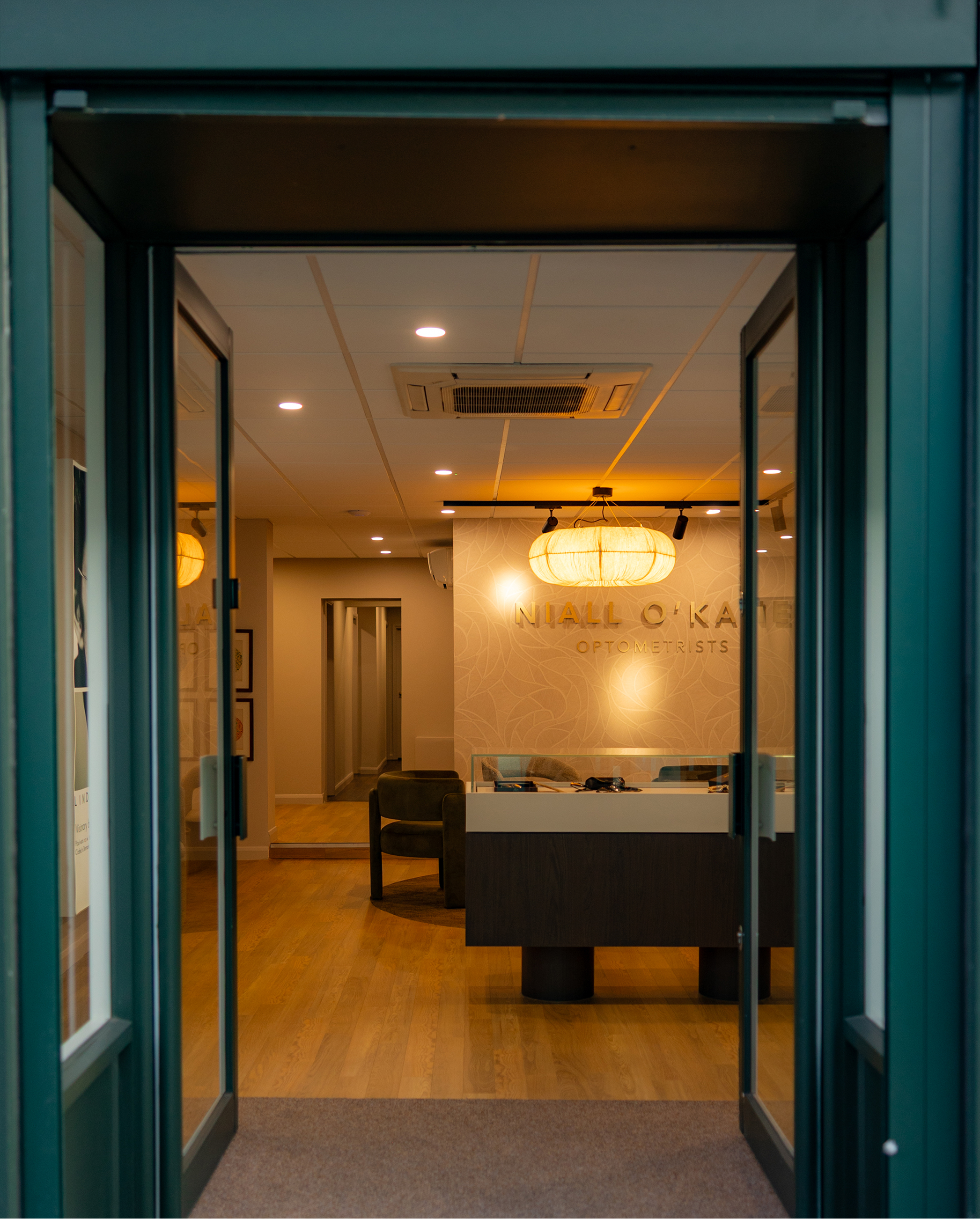 Niall O'Kane Optometrists office interior with warm lighting and reception desk