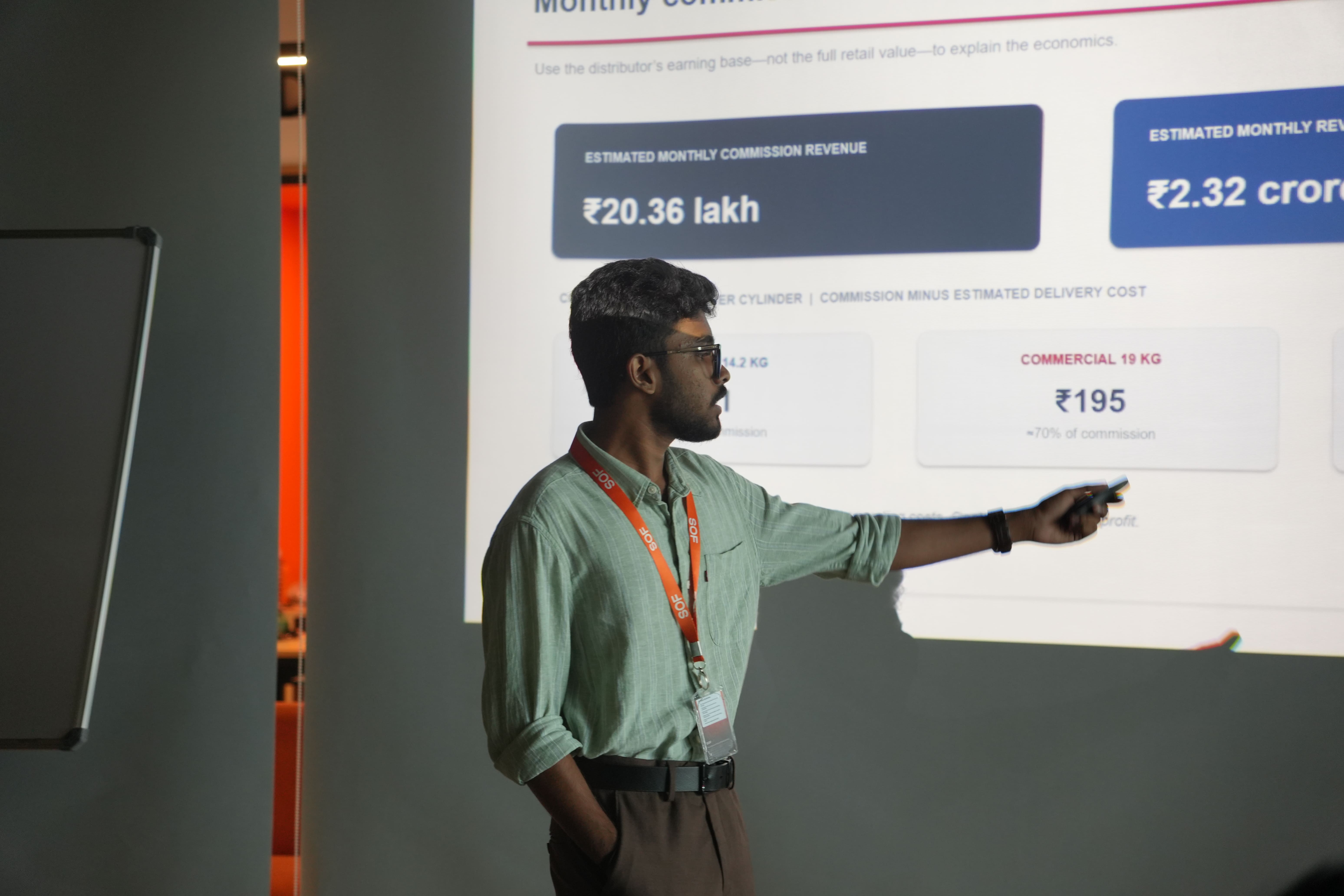 SOF student presenting business revenue numbers on a screen, learning to build a business by doing after 12th