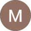 Ruskea ympyrä, jossa valkoinen M-kirjain.