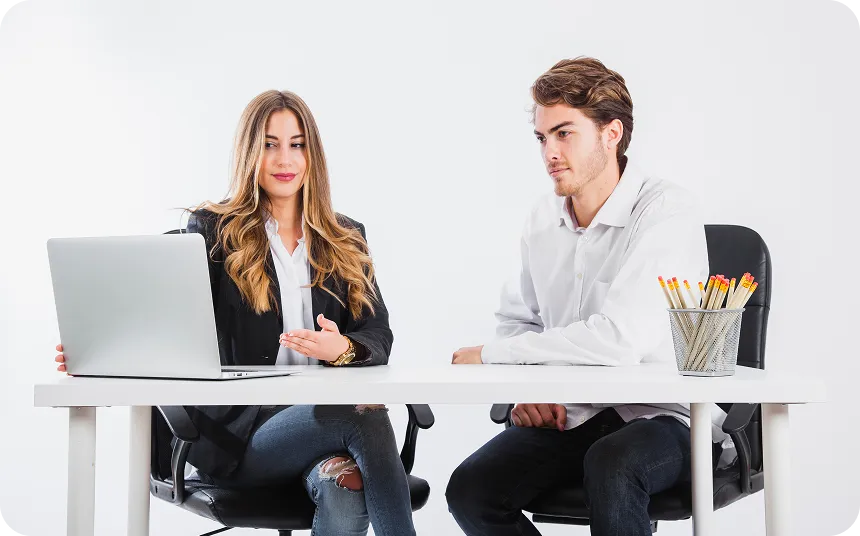 Multiple white wind turbines with rotating blades against a clear blue sky.