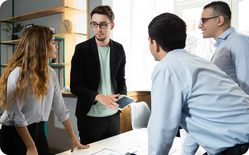 Several wind turbines standing in a green field under a partly cloudy sky.
