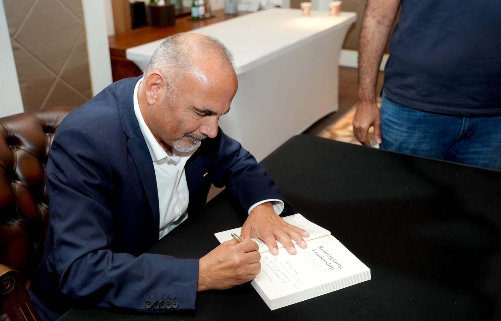 Dr. Elie Daher signing a copy of Reimagining Leadership
