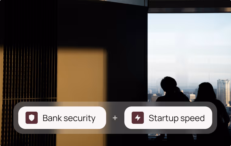 Silhouettes of two people sitting by a large window with city view, overlay text reads 'Bank security + Startup speed'.
