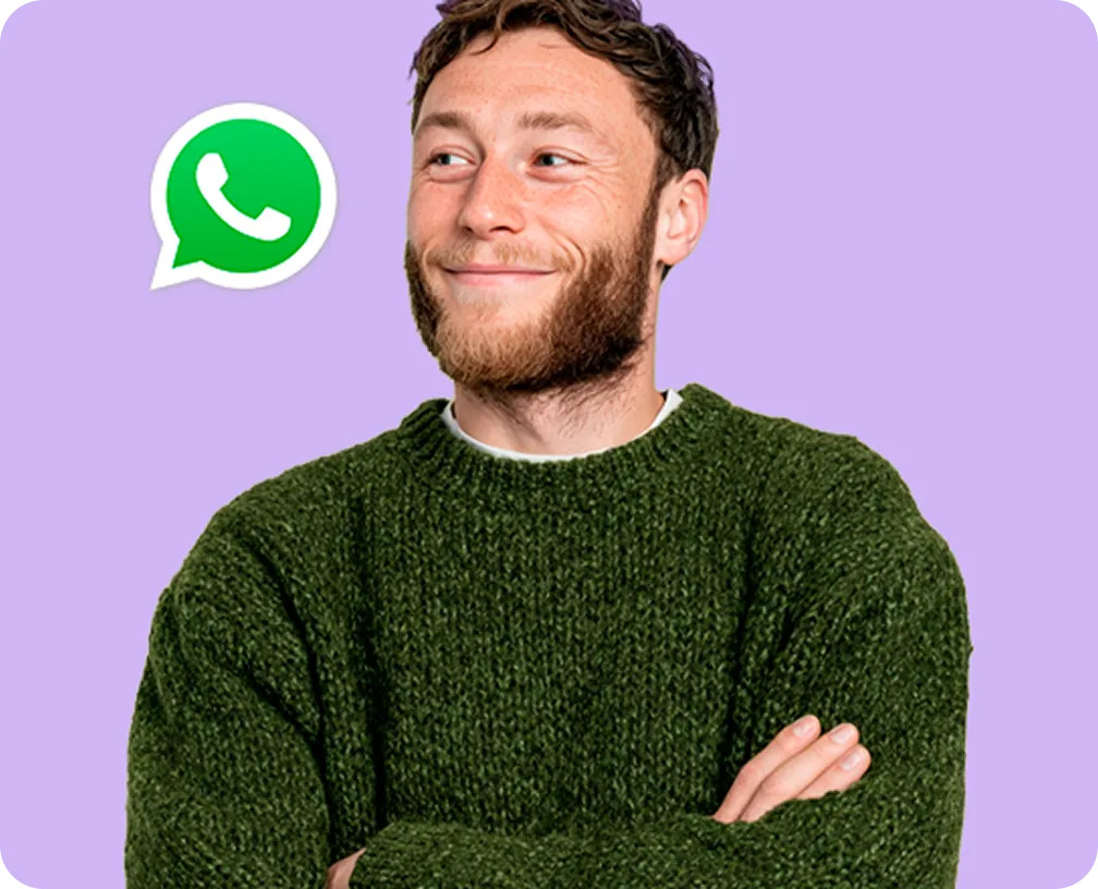 Hombre sonriente con suéter verde mirando hacia un ícono de WhatsApp sobre fondo lila.