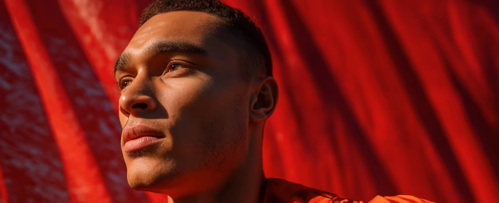 Abstract blurred image of a person’s face with vibrant red, pink, and teal light streaks.