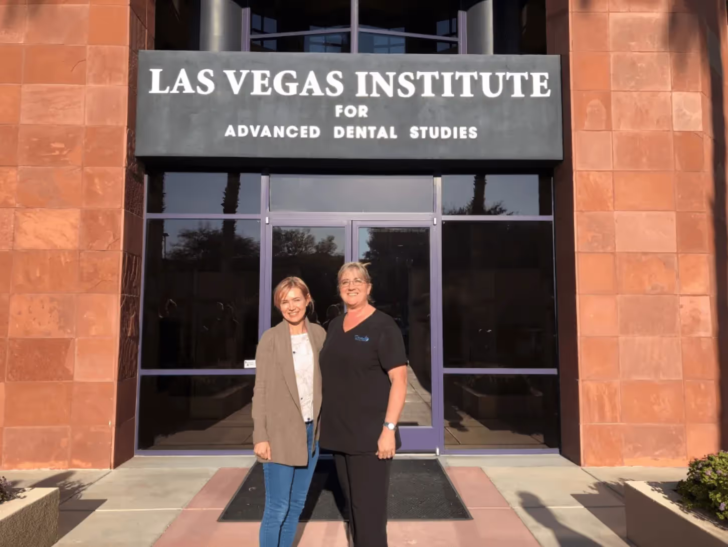 Two women standing in front of Las Vegas Institute