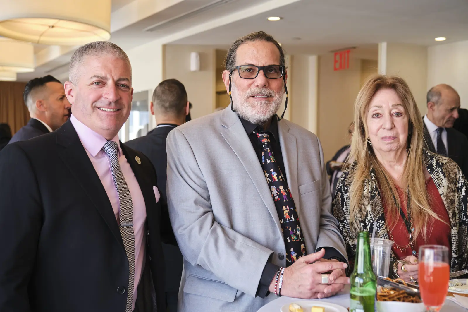 Three guests posing together at school event reception
