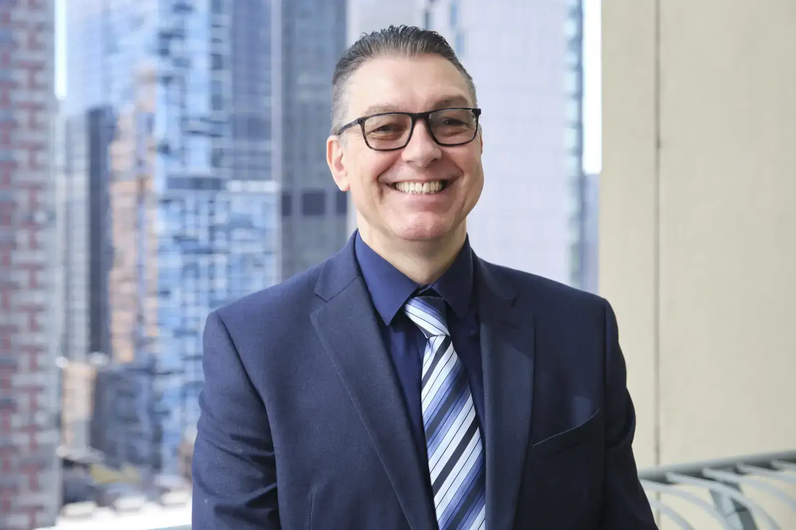 Professional headshot of smiling man in business suit