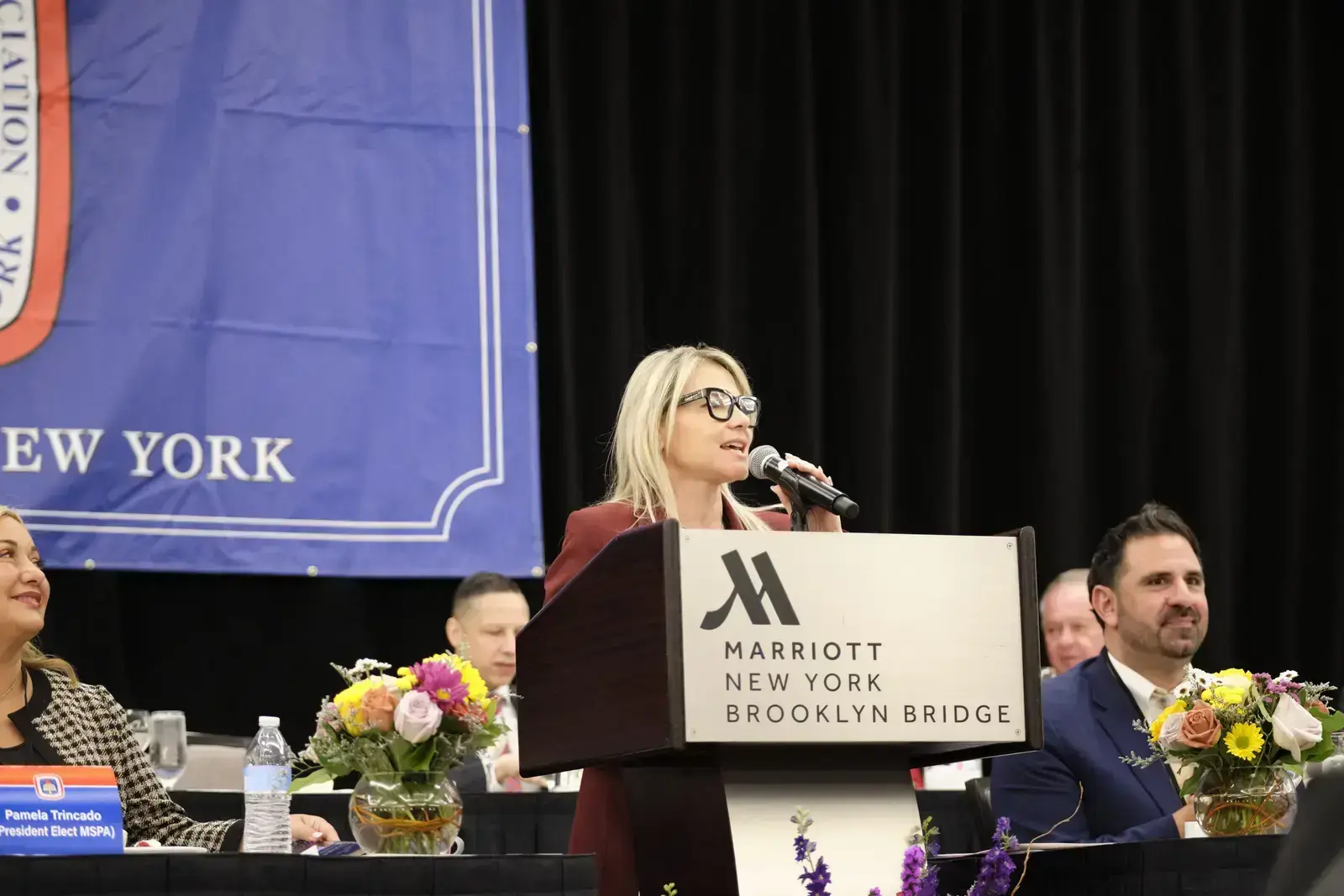 Woman speaking at podium during school board meeting