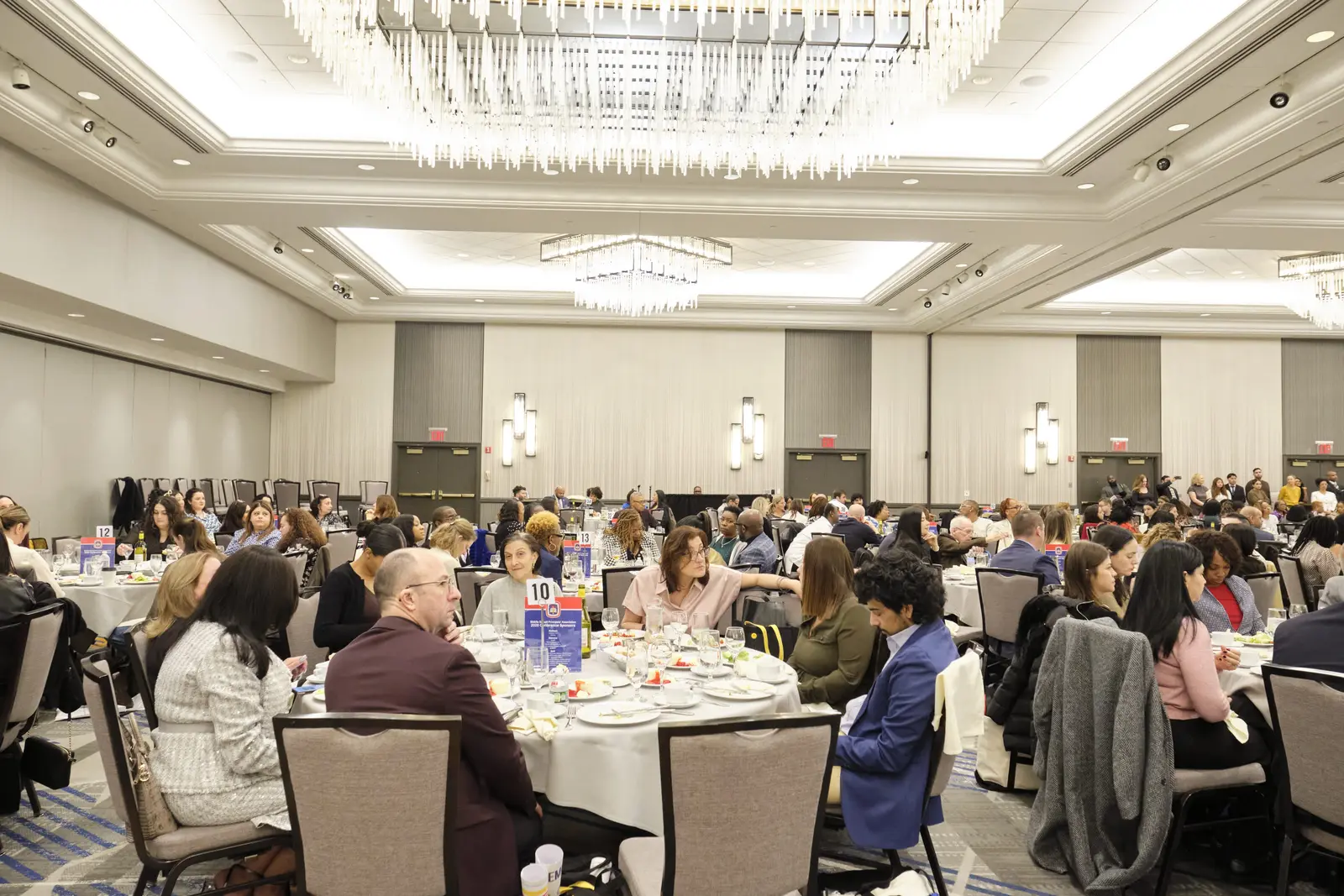 Attendees networking and dining at banquet hall event