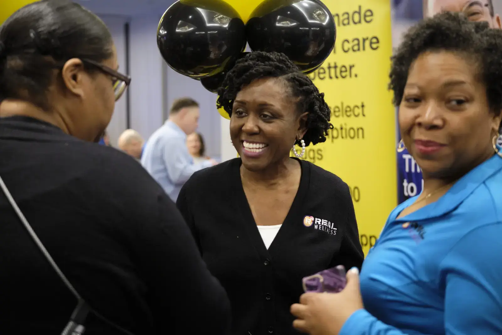 Three women conversing at career fair event