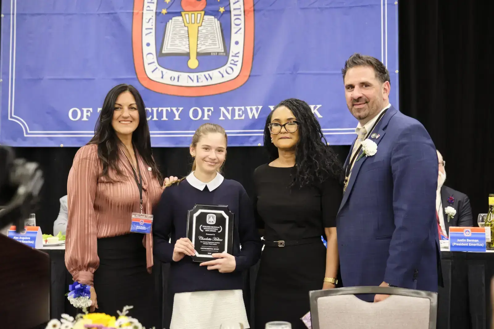 Student receiving award plaque with school administrators at ceremony