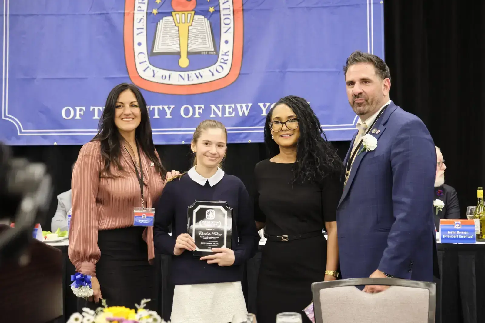 Student receives award from school officials at City of New York ceremony