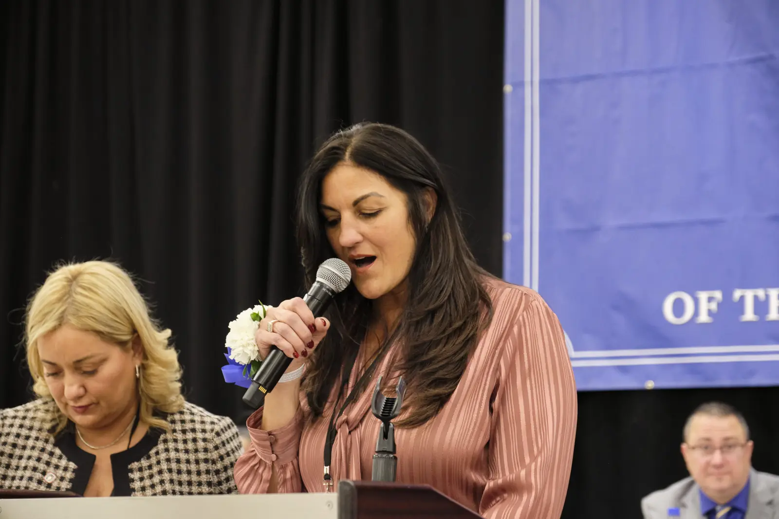 Woman speaking at microphone during school event
