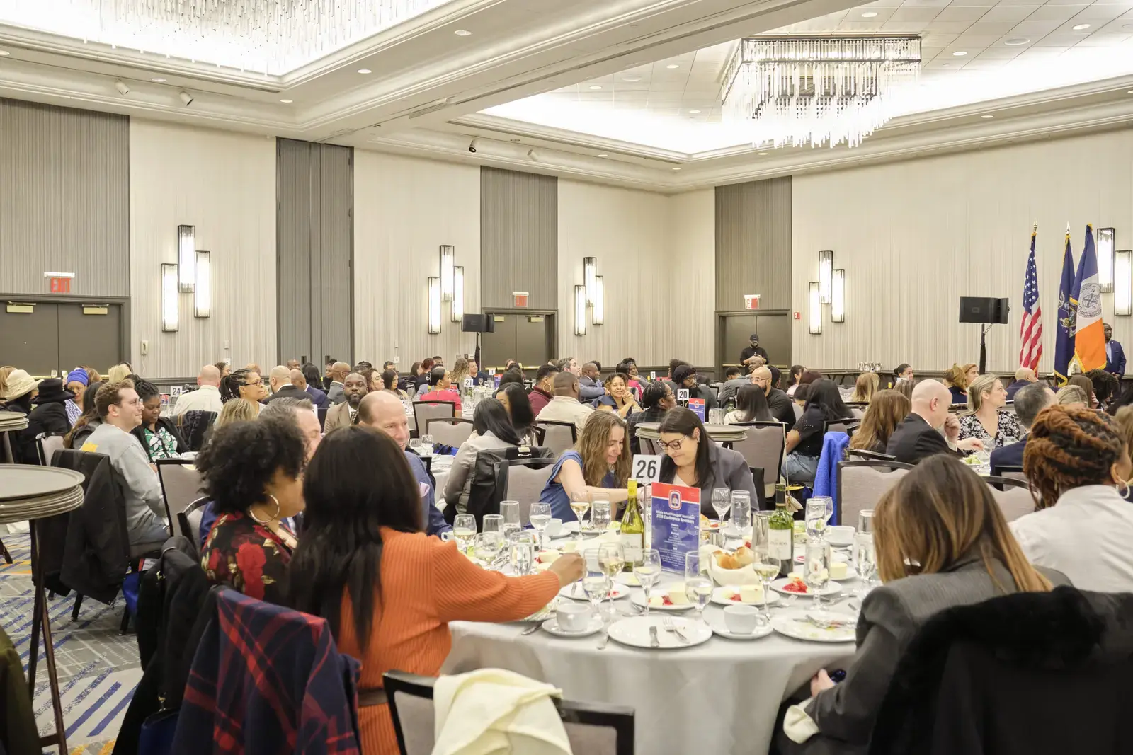 Attendees seated at round tables during formal luncheon event