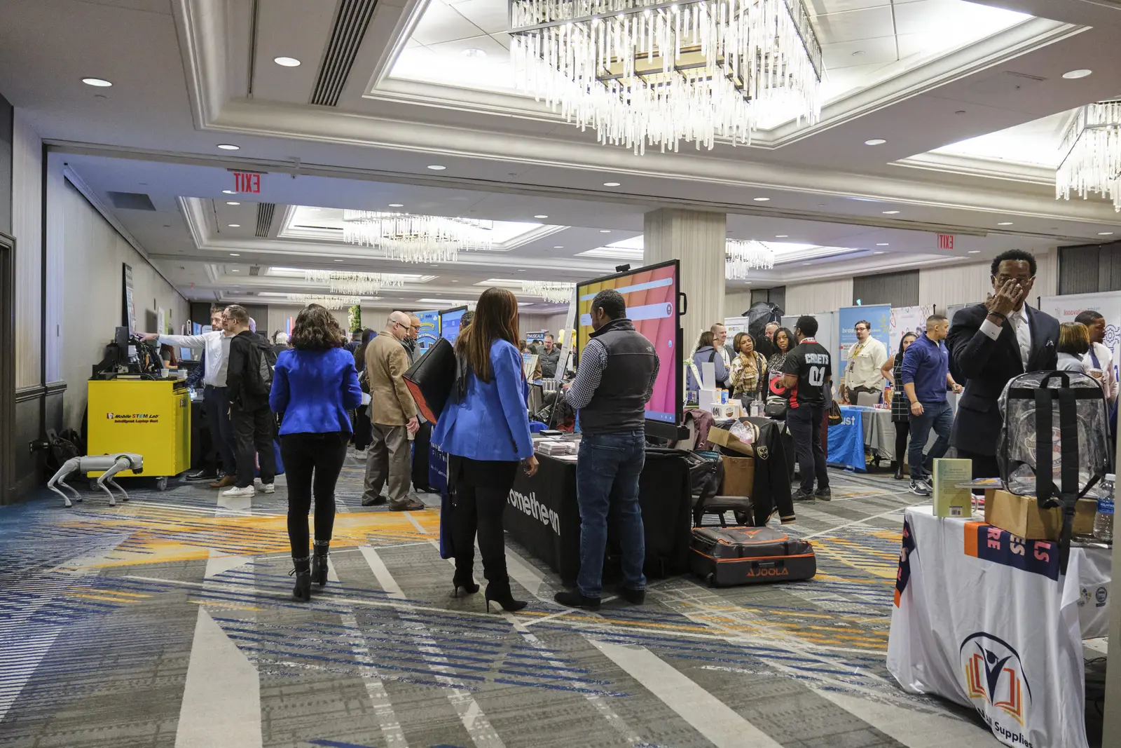 Students and visitors exploring exhibits at school STEM fair