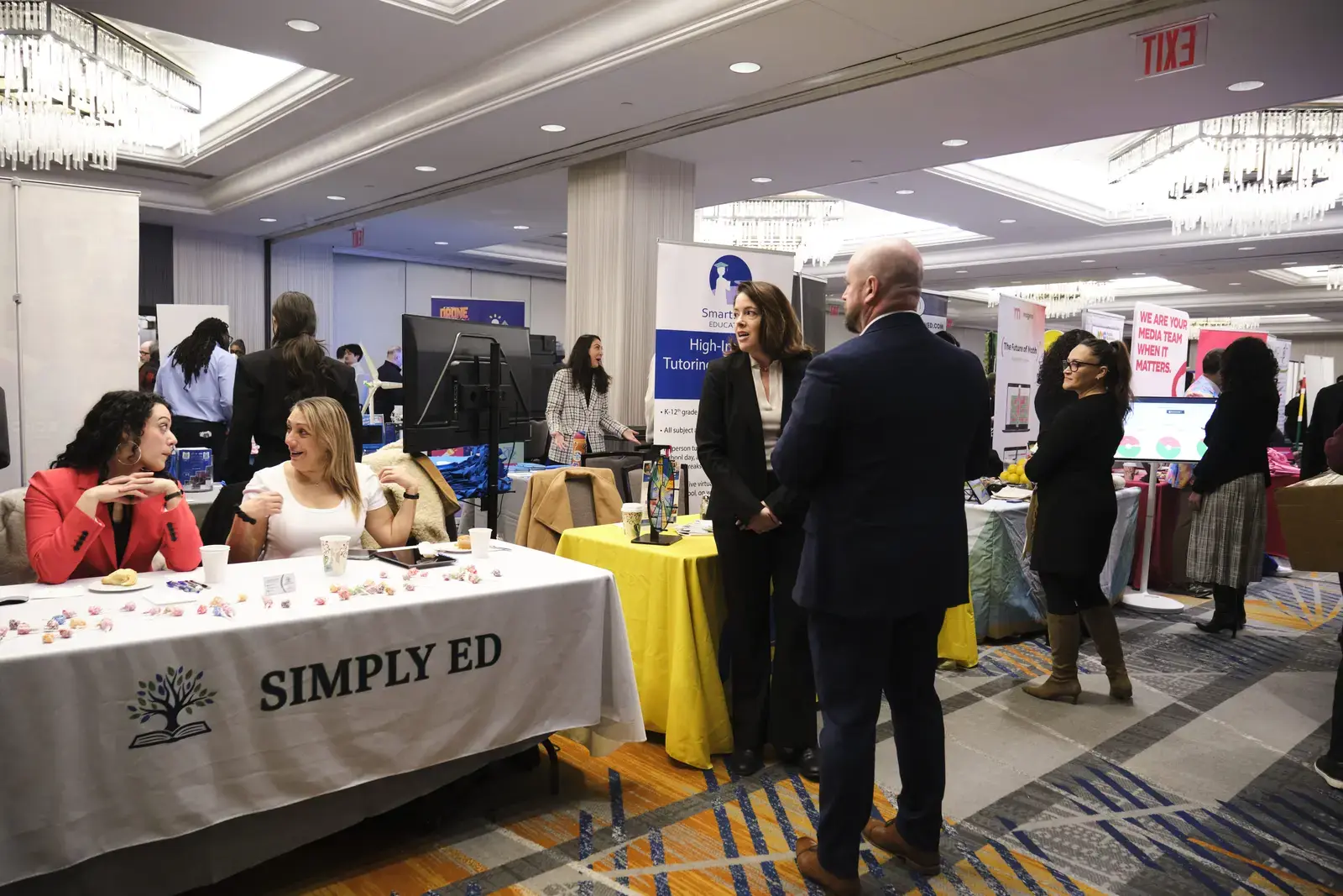 Attendees networking at education resource fair with vendor booths