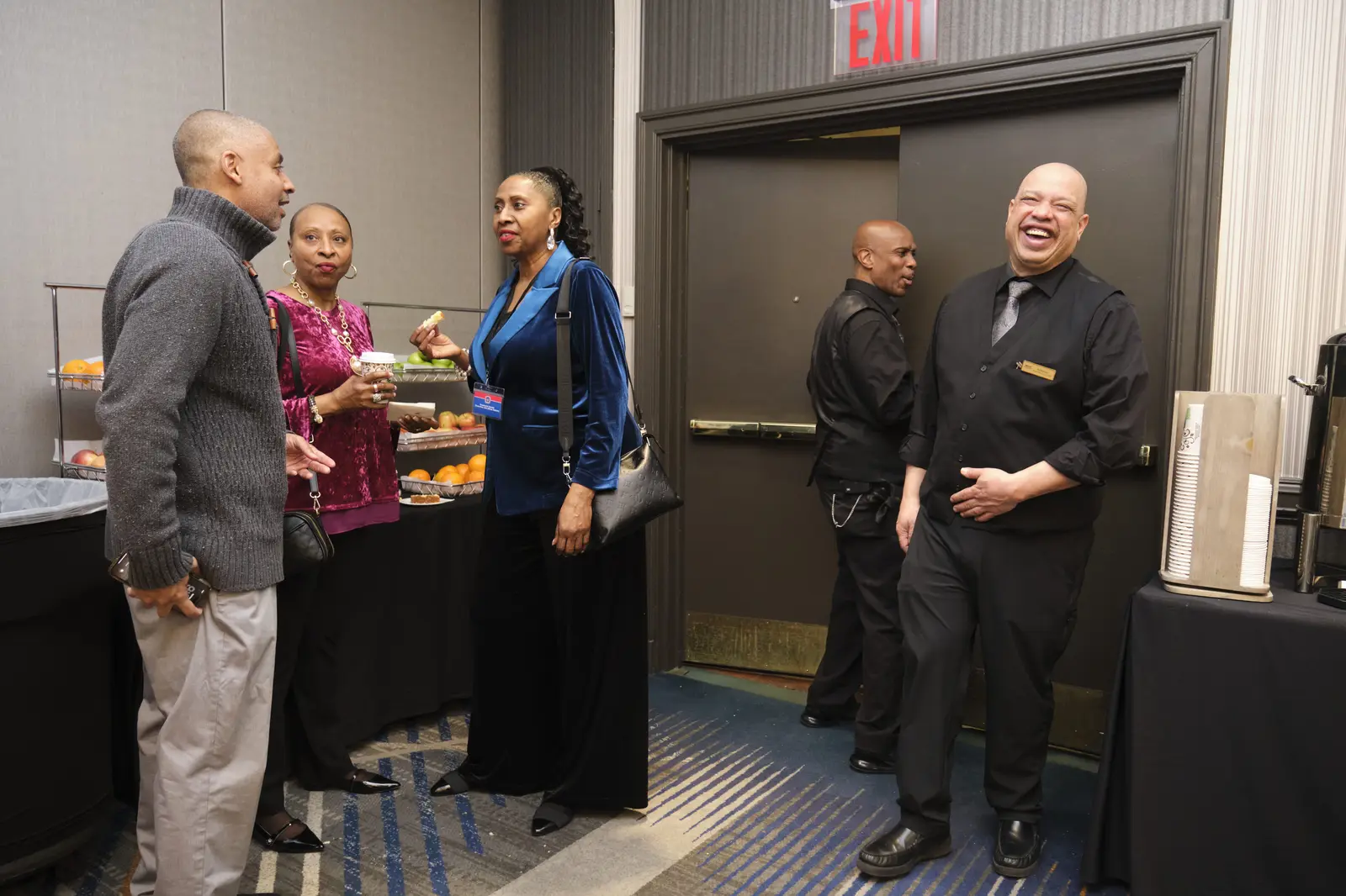 Staff and guests conversing at school event reception