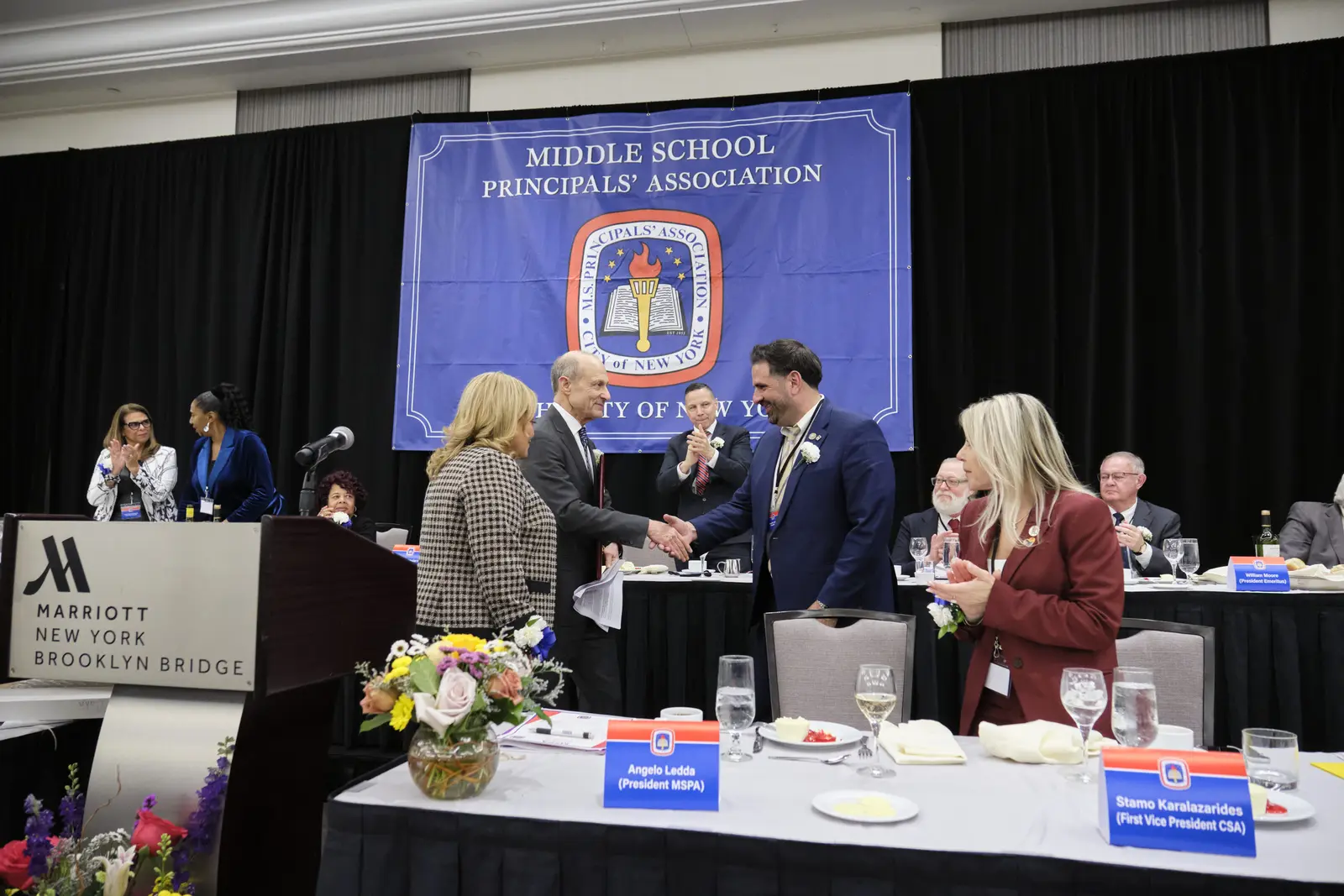 Middle school principals shaking hands at association awards ceremony