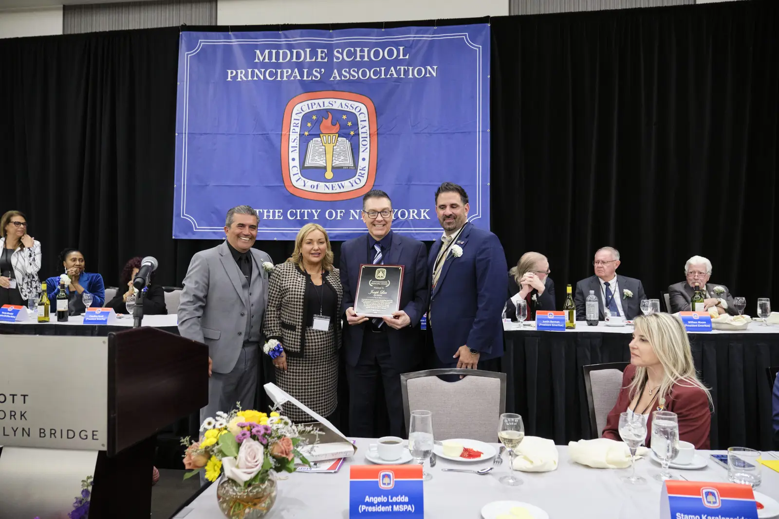 Four people presenting award at Middle School Principals' Association event
