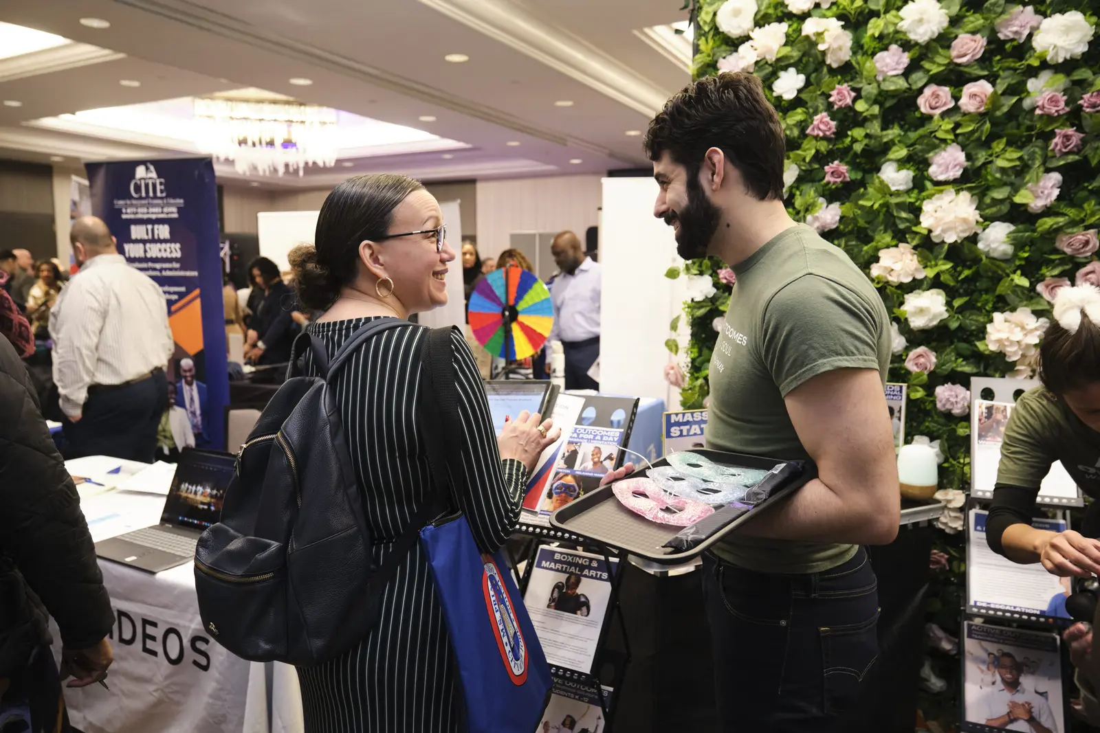 Student speaks with college representative at campus fair booth