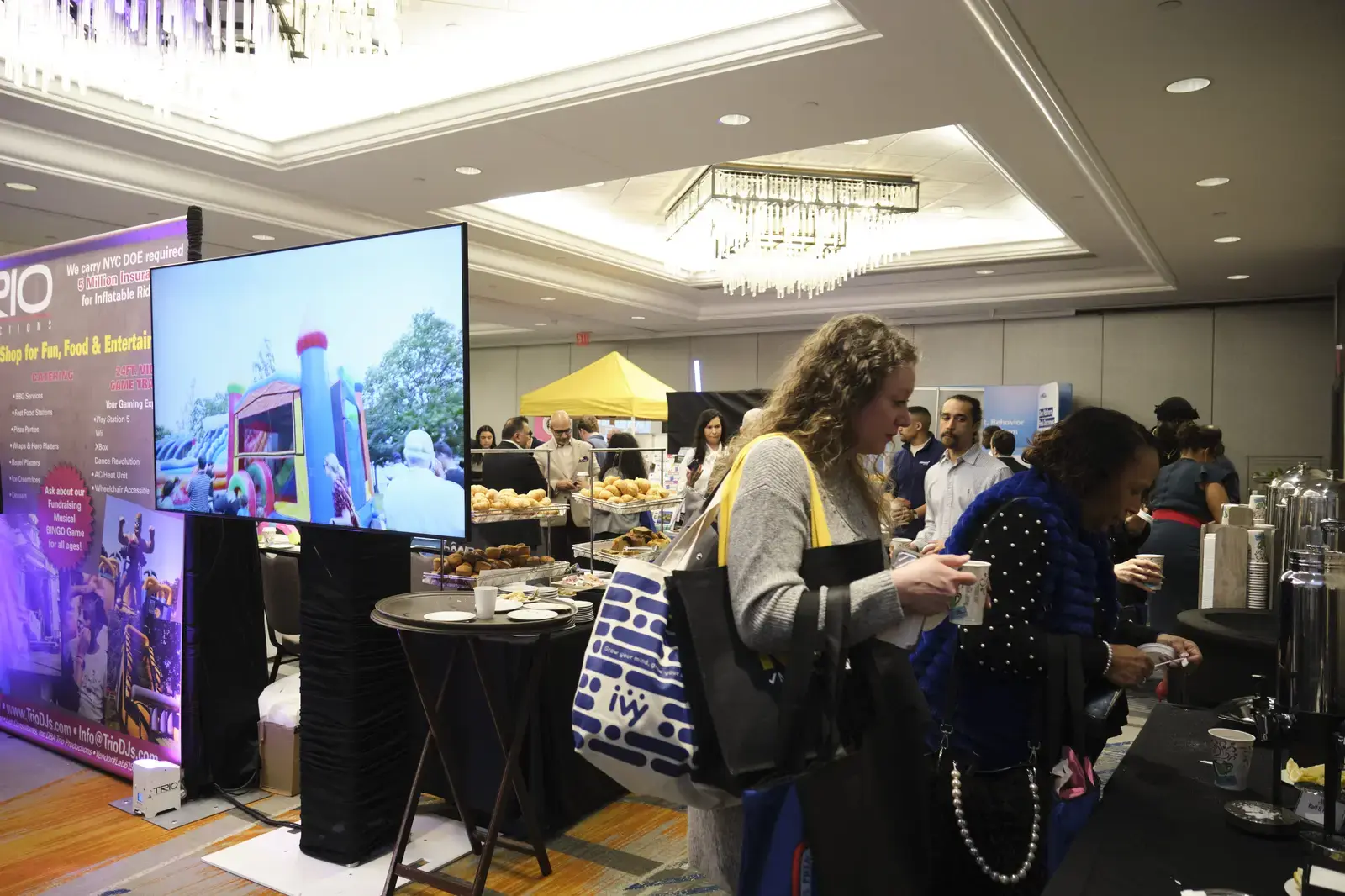 Attendees networking and gathering refreshments at indoor event