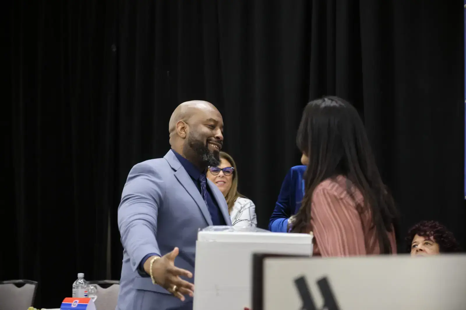 Administrator shaking hands with student at recognition ceremony