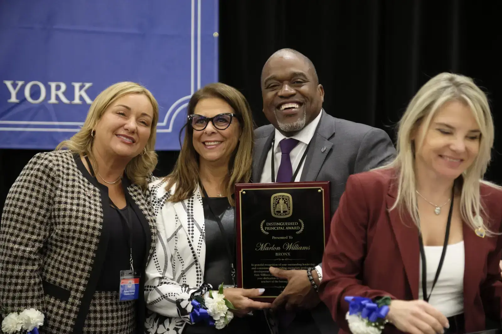 Principal receiving Distinguished Principal Award with three colleagues
