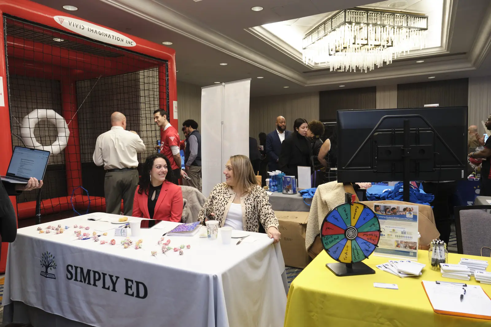 Vendors at exhibition booths engaging with attendees at career fair