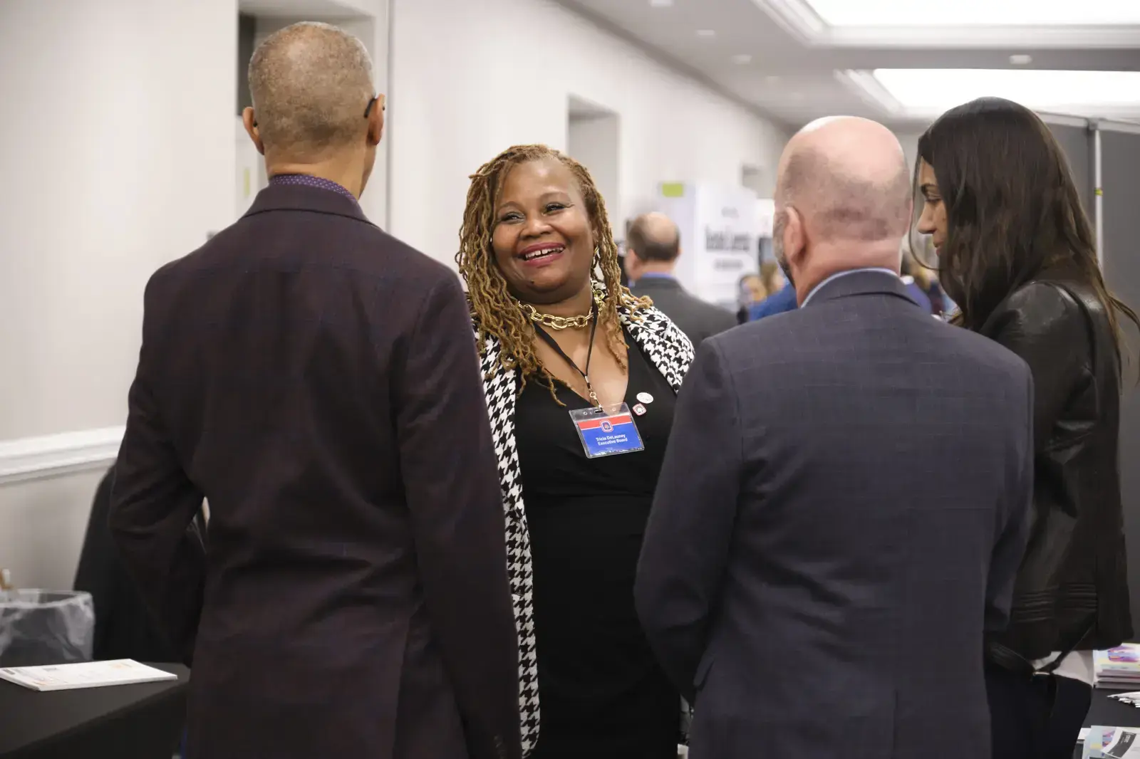 Staff member greeting attendees at school networking event