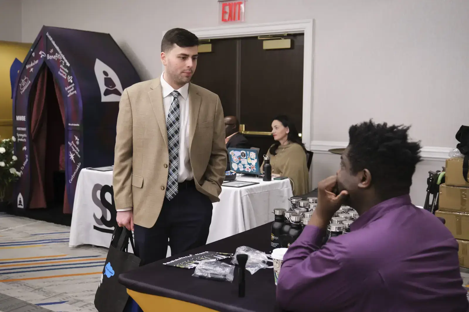 Representative speaks with student at college fair booth