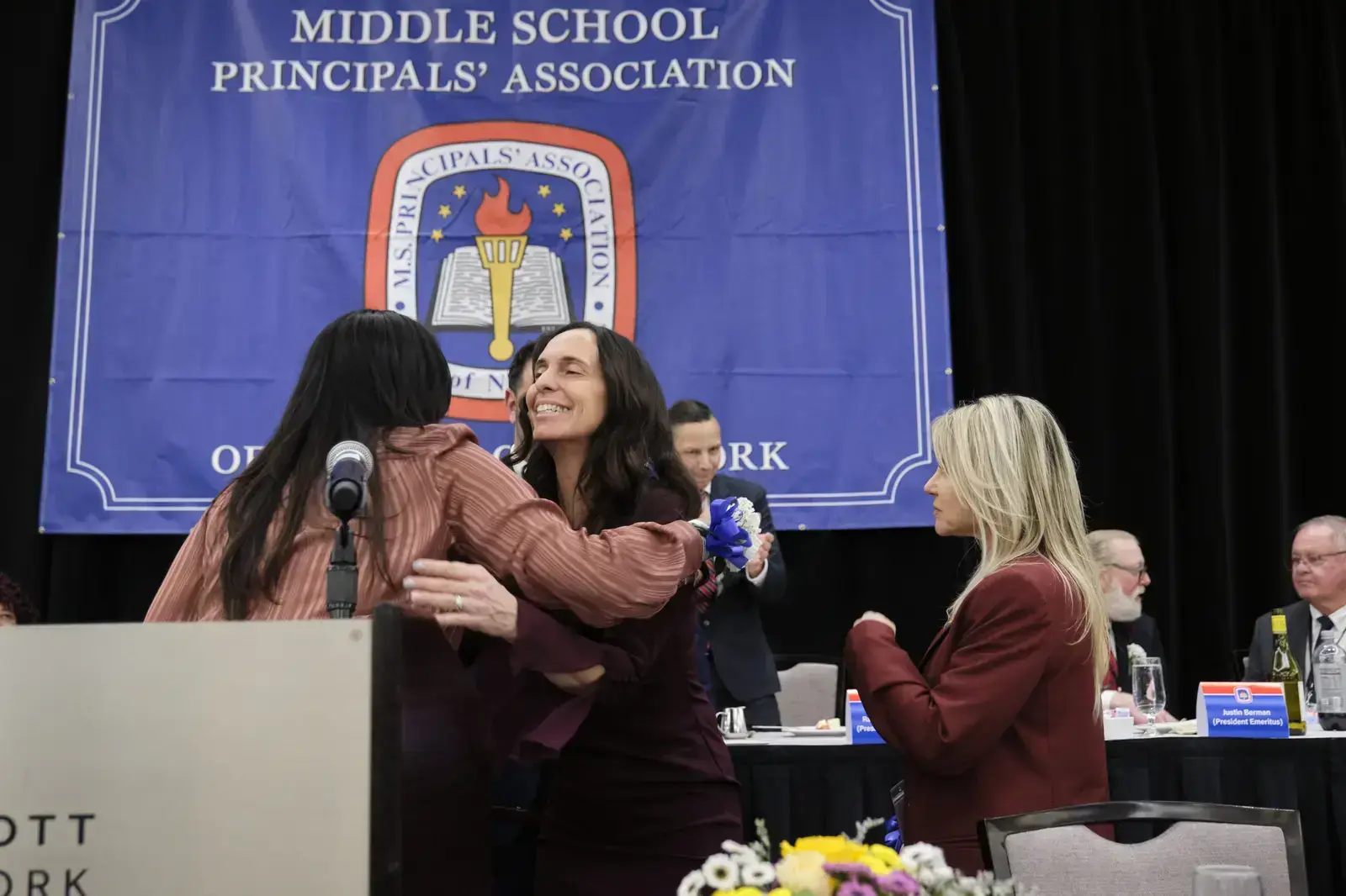 Two women embracing at Middle School Principals' Association event