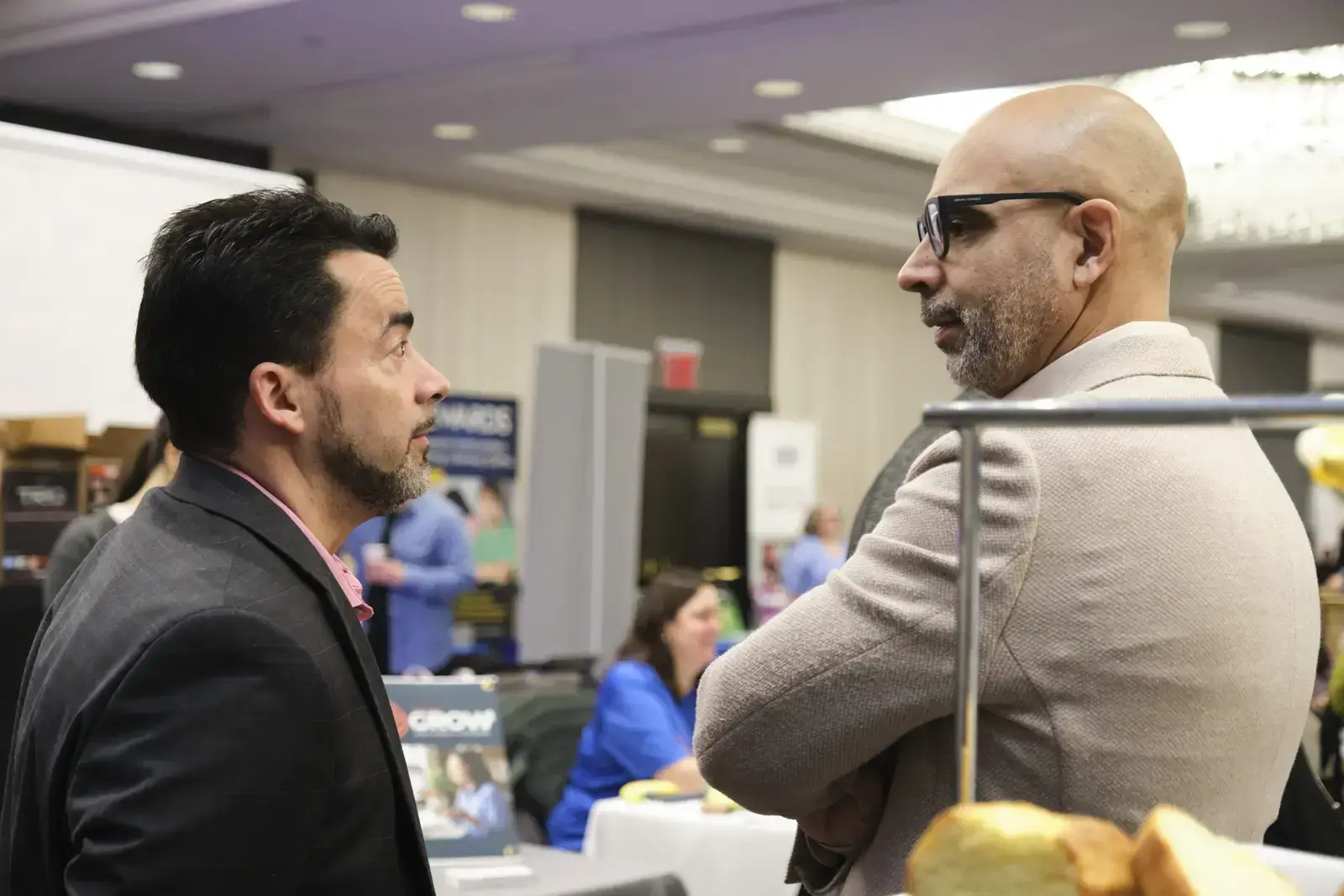 Two professionals having a conversation at a school event