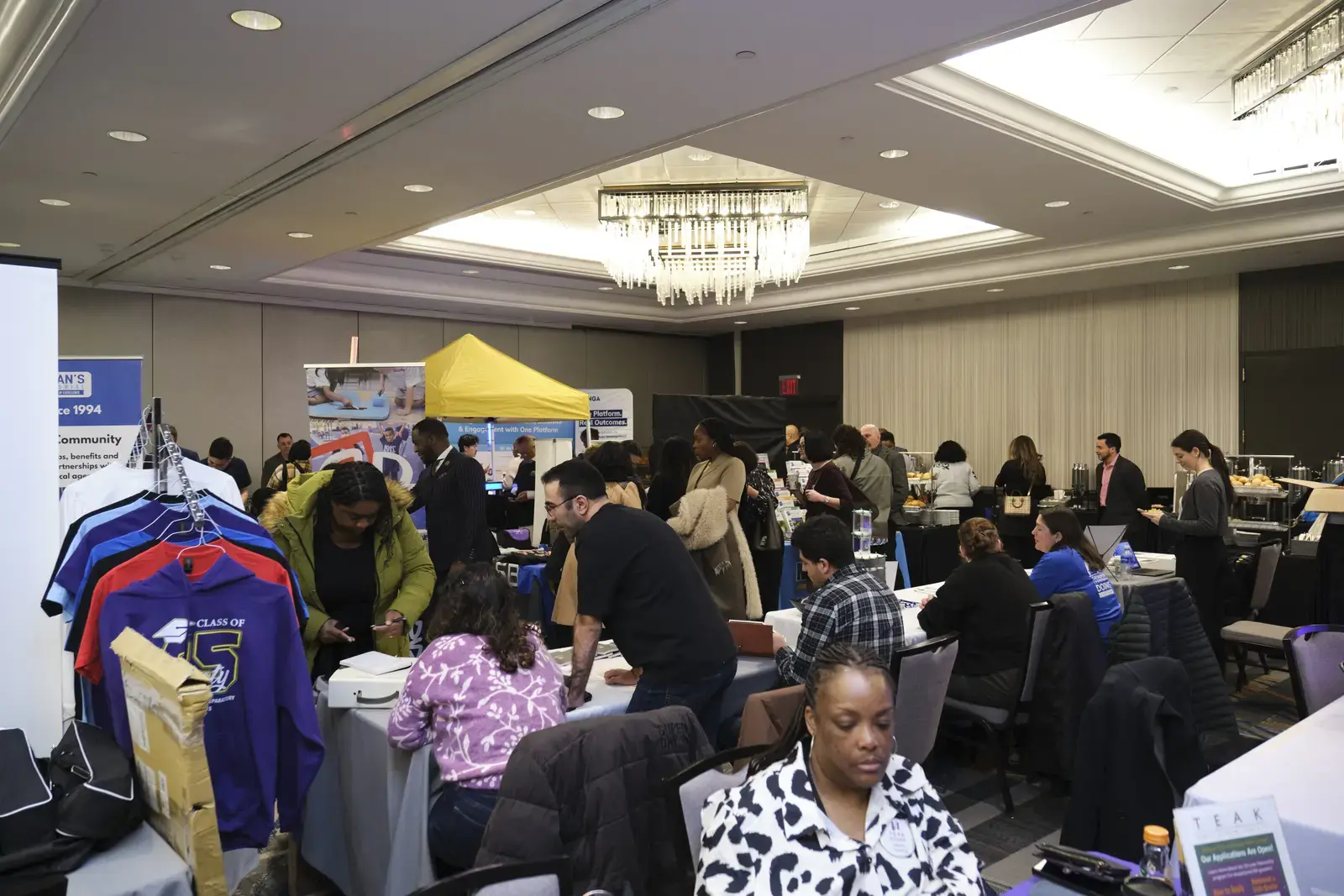 People networking and visiting booths at school community event
