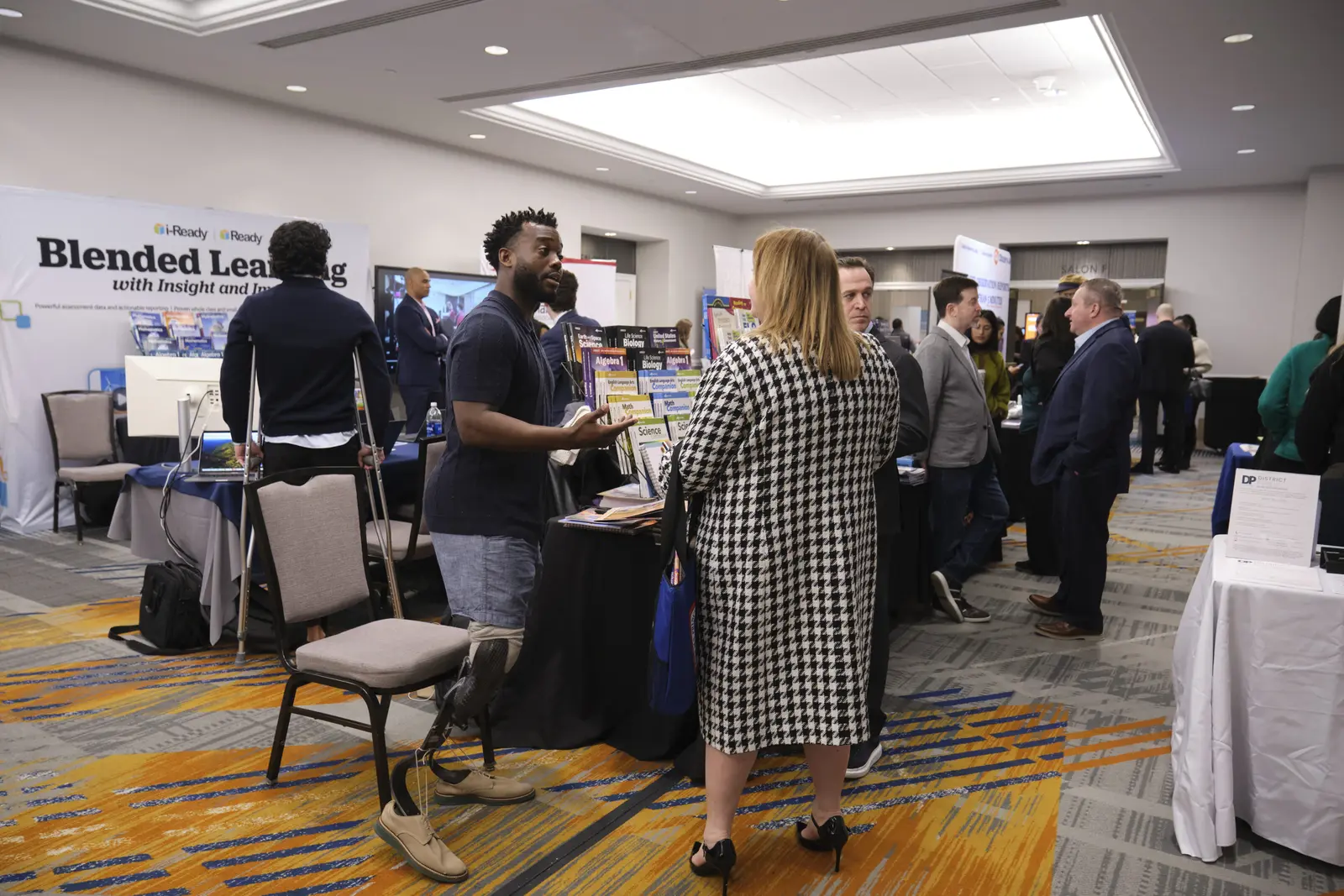 Educators browsing blended learning resources at conference exhibit booth