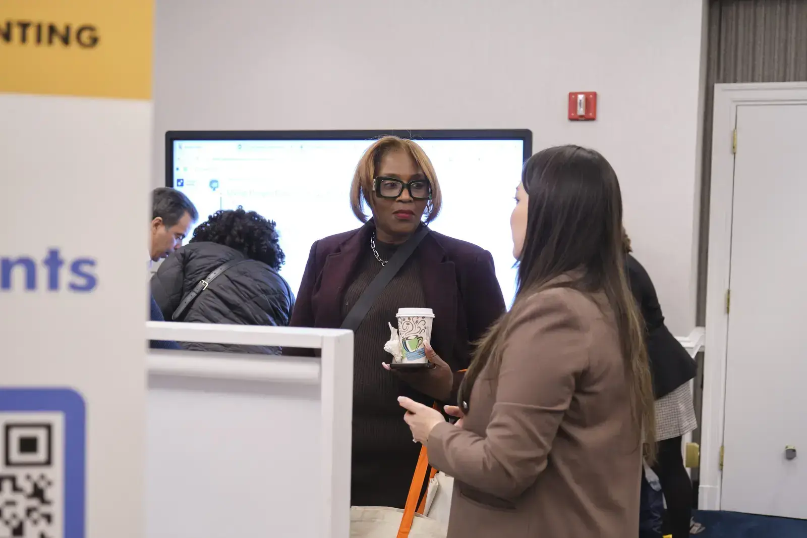 Two staff members conversing at school reception desk