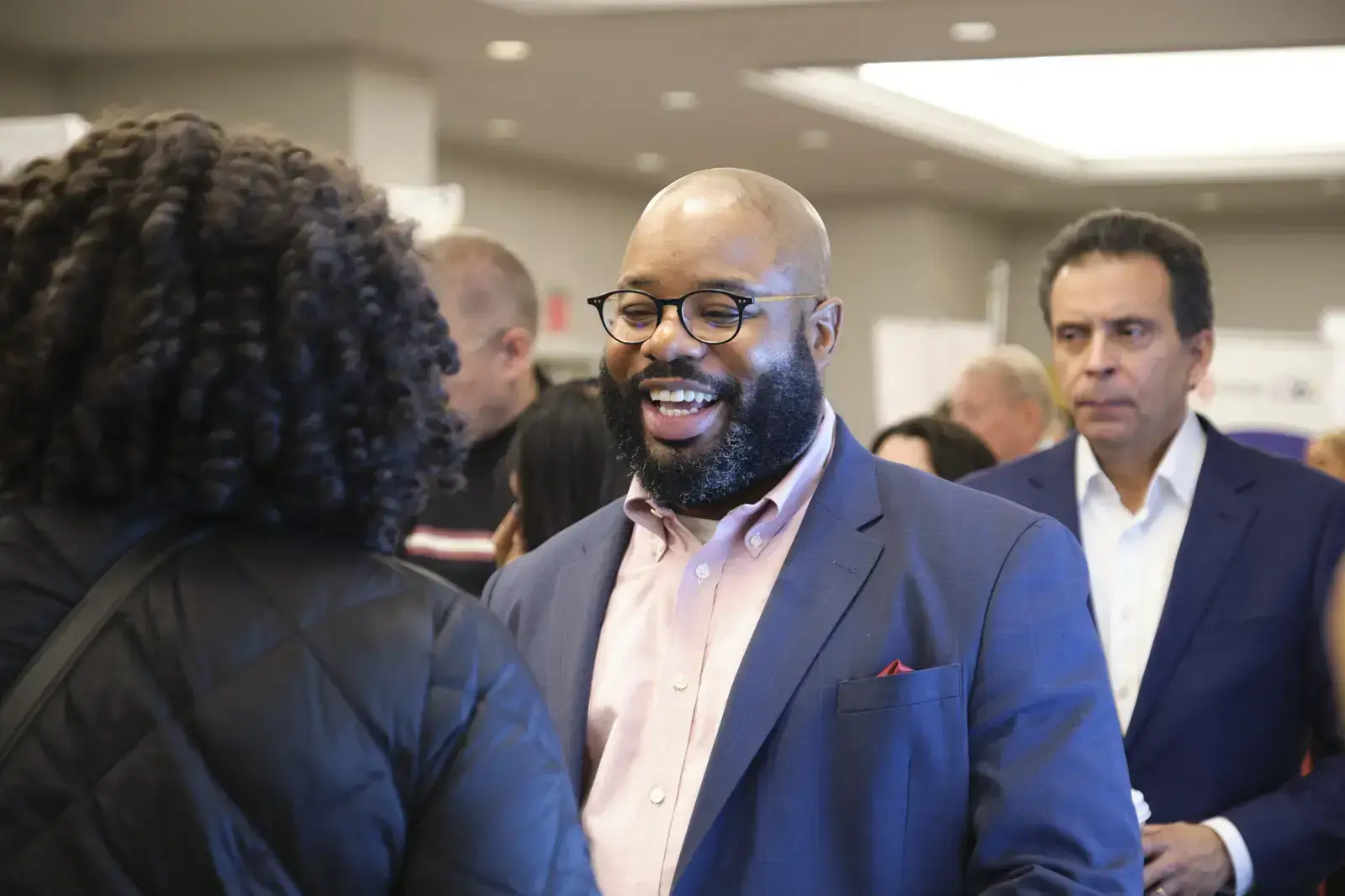 Professional greeting attendees at school networking event