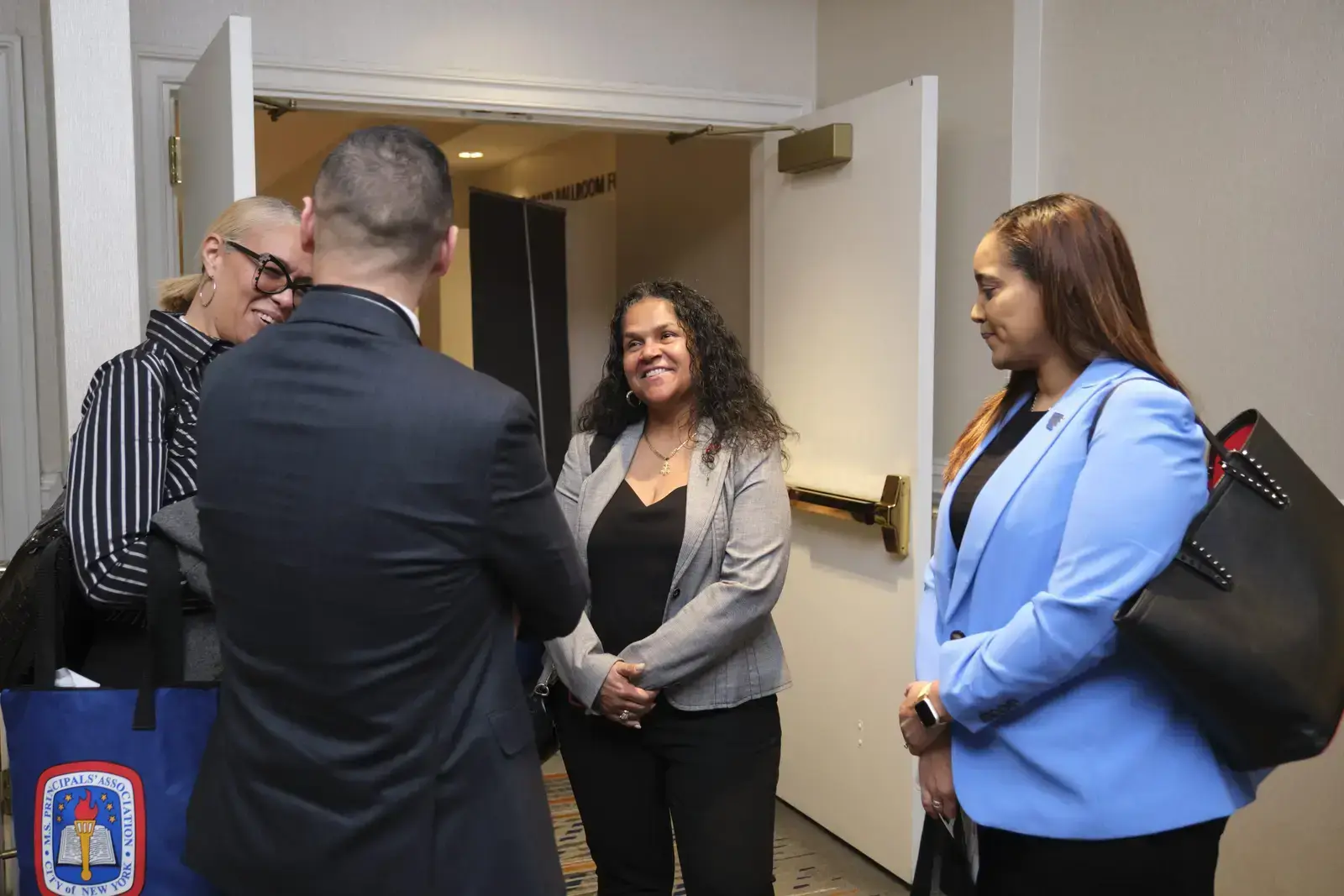 School staff greeting and shaking hands in hallway