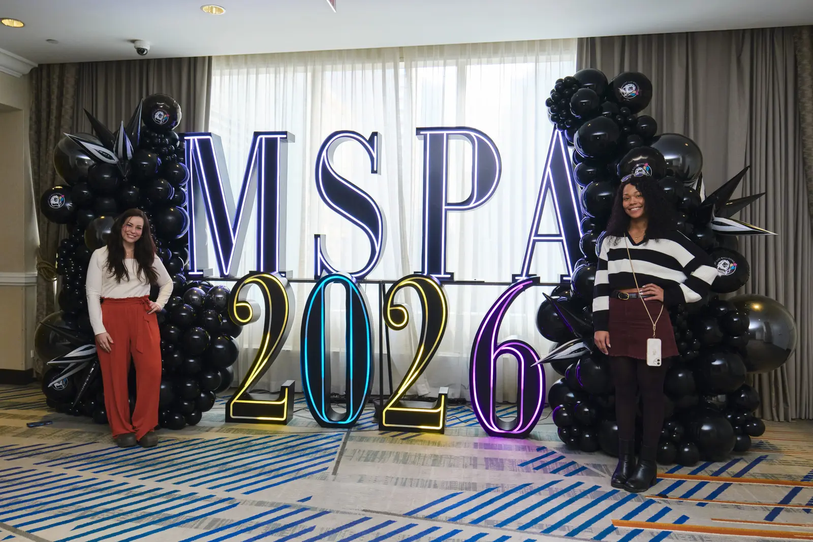 Two students posing at MSPA 2026 event with balloon decorations