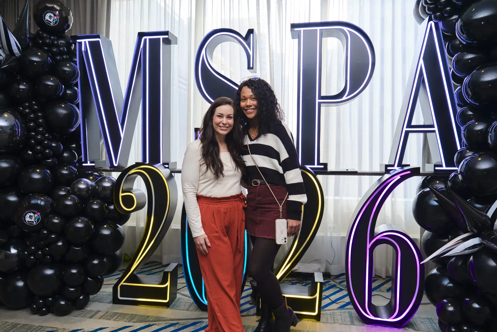Two students posing at MSPA 2026 event backdrop