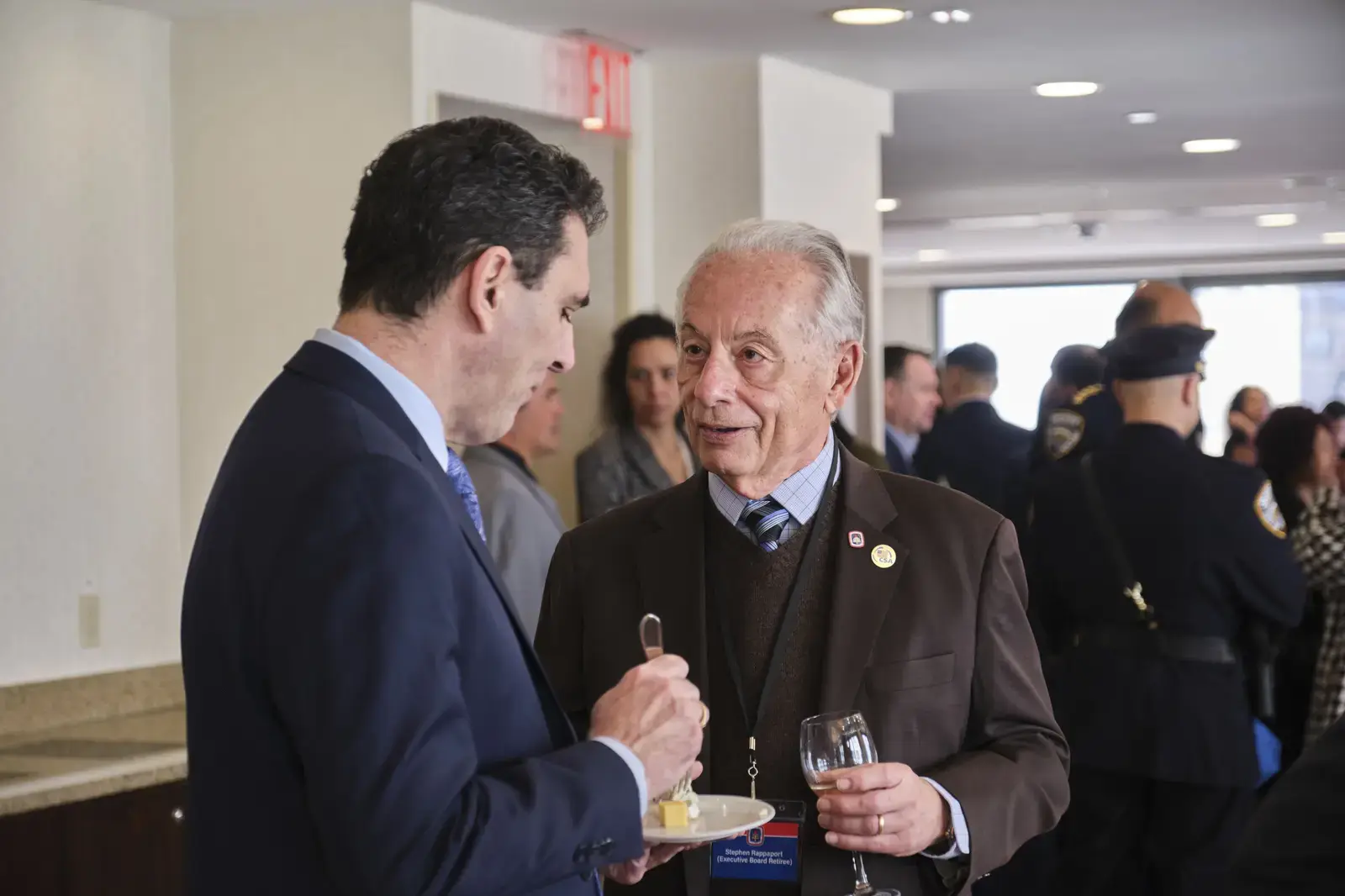 Two professionals conversing at school networking event