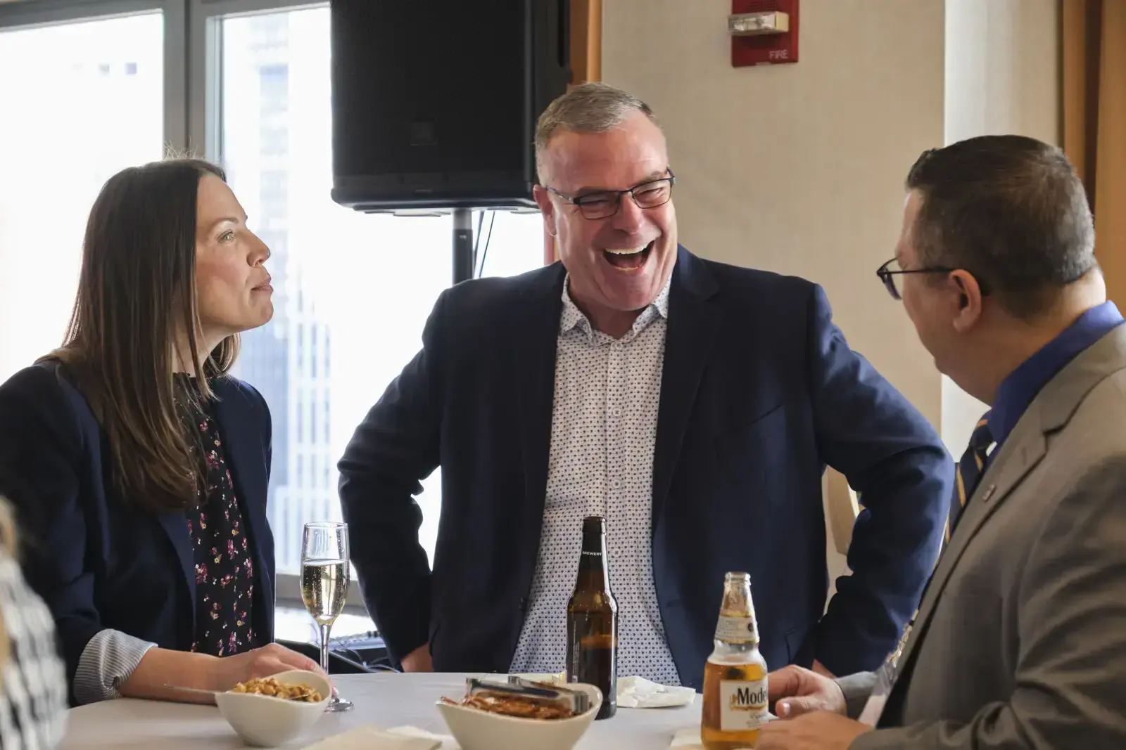 Three professionals sharing a meal and conversation at table
