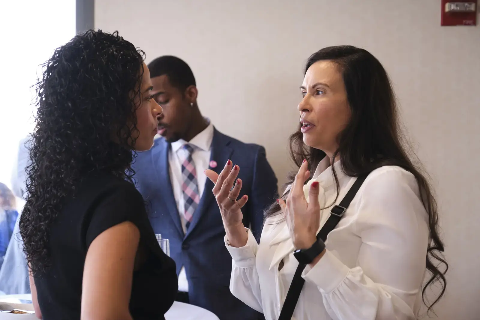 Three professionals engaged in discussion at school event