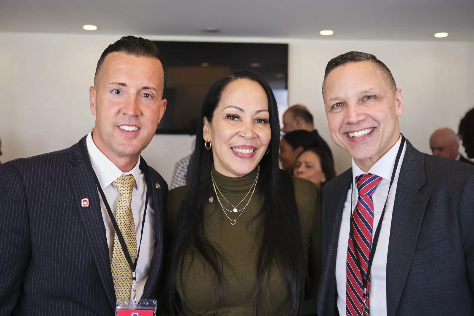 Three school administrators smiling together at professional event