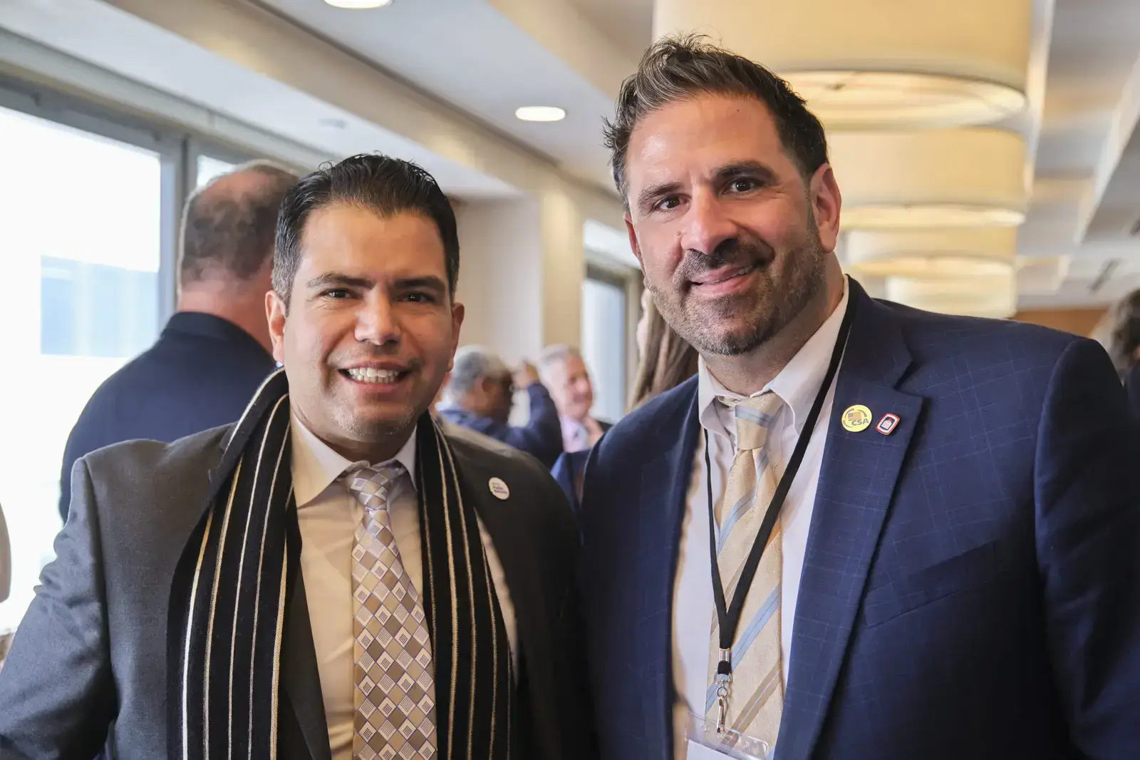 Two professionals in business attire smiling at school event