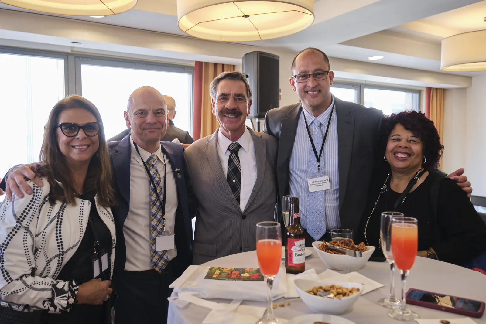 Five professionals posing together at a networking event